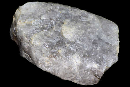 A shard of raw vein icy quartz on a black background close up