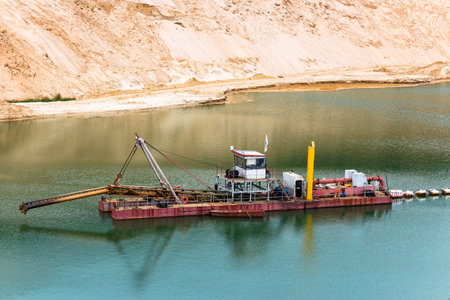 Dredger on a flooded sandy quarry with a raised soil intake deviceの写真素材