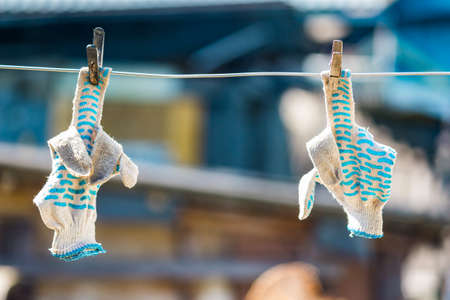 Work gloves to dry on a clothesline, reminiscent of an indecent gesture with a middle finger fuck youの写真素材