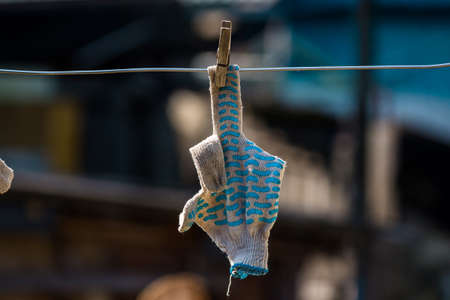 Work gloves to dry on a clothesline, reminiscent of an indecent gesture with a middle finger fuck youの写真素材