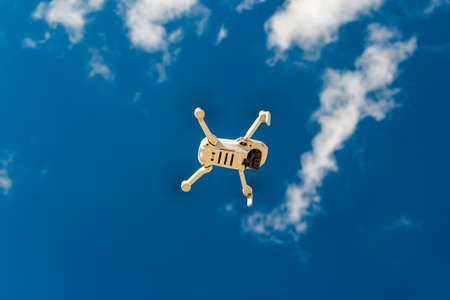 Small white drone DJI Mini 2 in flight against blue sky, bottom view: Russia - May 2021のeditorial素材