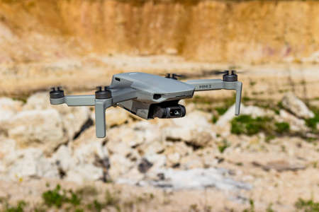 Small drone DJI Mini 2 in flight against the backdrop of a rocky landscape: Russia - May 2021のeditorial素材