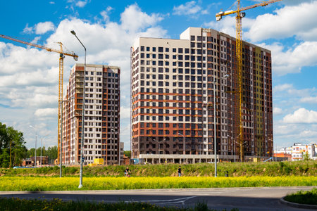 Construction of a modern residential area on the outskirts of the city, new buildings and tower cranes: Russia - May 2021のeditorial素材
