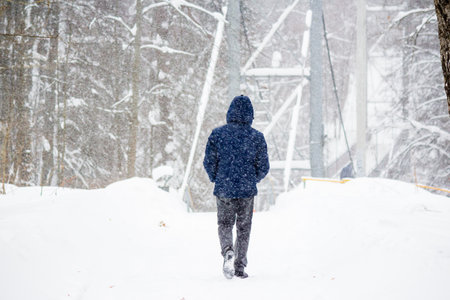 Pedestrian on the street in winter during a heavy snowstorm and poor visibilityの写真素材