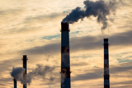 Industrial landscape with a view of tall chimneys releasing puffs of steam into the atmosphereの写真素材