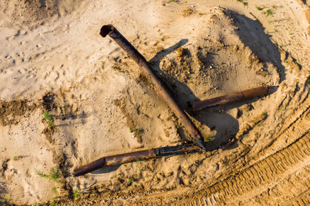 Old rusty pipes from a dredger on a sand pit, top viewの写真素材