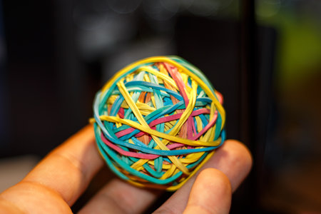 A ball made of multi-colored rubber bands in the handの写真素材