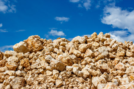 Stone blocks piled in a heap against the background of clouds, stone mining at a limestone quarryの写真素材