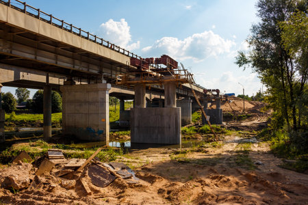 Robust bridge construction, a massive concrete overpass in progress. Steel girders, unfinished...