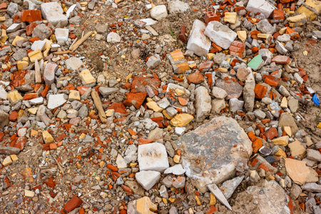 A textured mix of construction rubble, broken bricks, and concrete. This aggregate forms a rough road fill or groundwork baseの写真素材