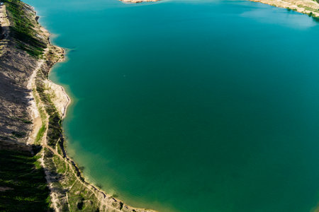View from above of a sandy shore surrounding a large body of water, a flooded sand quarryの写真素材