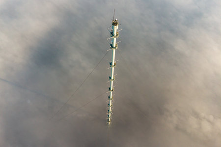 Aerial view of 300-meter meteorological mast in fog and clouds. Obninsk, Russia. November 2021