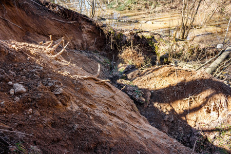Landslide on a sandy slope of a ravine caused by erosion