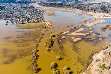 Spring flood on the river with flooded fields in the countryside, aerial viewの写真素材