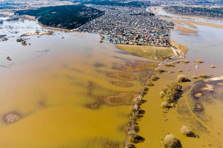 Spring flood on the river with flooded fields in the countryside, aerial viewの写真素材