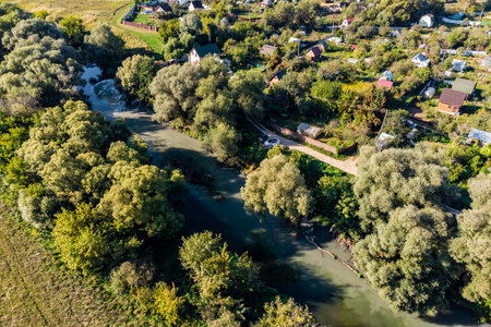 Top view of muddy water in a river near a sewage treatment plant discharge, summer cottage development by the riverの写真素材