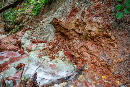 Vivid variegated clay strata from the Carboniferous period exposed by erosion in a ravine slope. A...