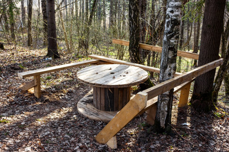 Rustic outdoor picnic spot: improvised wooden table made from a cable spool in a sunny, quiet forest. Perfect for a peaceful retreat or breakの写真素材