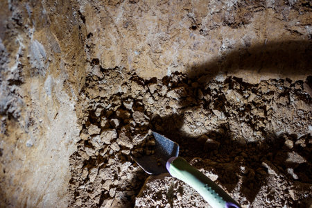 Digging soil in a hole with a metal shovelの写真素材
