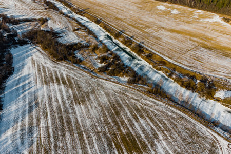 A view of the farmlands along the river in winter, seen from aboveの写真素材