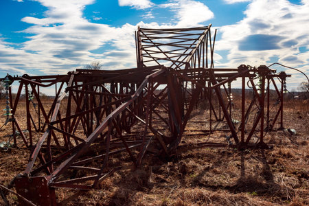 A old pole of a wire line is on the ground. The sky is cloudyの写真素材