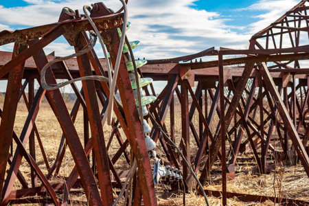A rusty power transmission pole lying on the ground, dismantling an old iron structureの写真素材