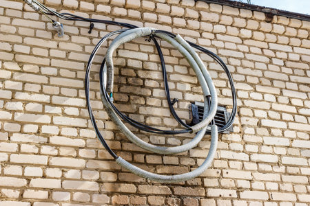 Electrical unconnected wires hanging on the wallの写真素材