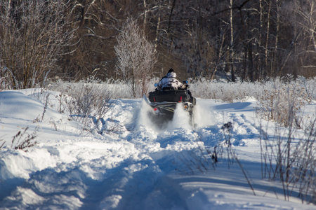 Action-packed ATV ride through pristine winter snow. Rider powers through, kicking up powder on a...