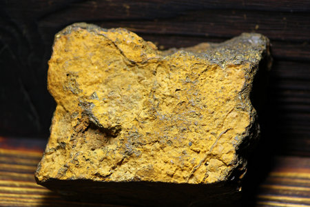 Rough yellow limonite iron ore specimen from Kaluga region, Russia, showcasing a textured mineral surface against a dark backdropの写真素材