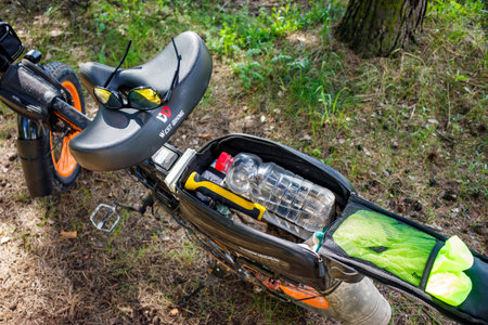 Bicycle seat with sunglasses resting on it, packed bag showing water bottle and tools ready for a spring ride in the woods: Russia - May 20, 2025のeditorial素材