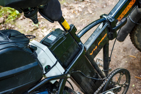 Close-up shot capturing an electric bicycle battery pack mounted to a black frame during a ride: Russia - May 5, 2025のeditorial素材