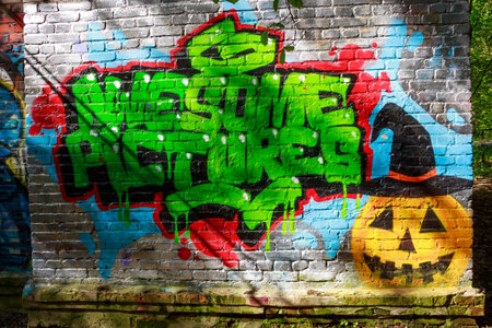 Vibrant green graffiti with dripping paint and a spooky jack-o'-lantern on a weathered brick wall outdoors: Russia - May 6, 2025のeditorial素材