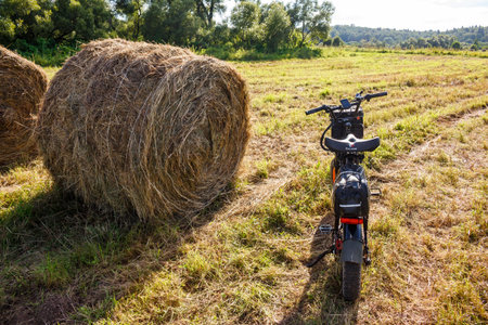 Electric bike ride through rural lands, hay bales collected in a farmer's field: Russia - August 2, 2025のeditorial素材