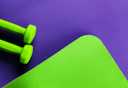 purple yoga mat and green yoga mat and dumbbellsの写真素材