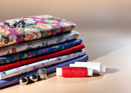 A variety of colored fabrics. Cotton, calico, chintz. Needlework. Handmade, thread, buttons, thimble.の写真素材