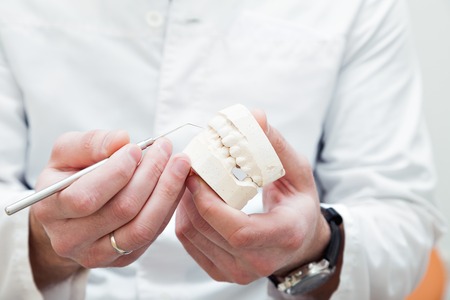 Dentist examining a patients teeth in the dentists chair at the dental clinic