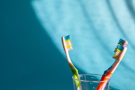 The dentist is checking the patient's mouth. Colorful toothbrushes in glass. Closeup.の写真素材