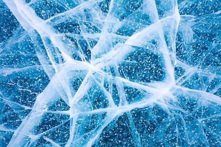 Lake Baikal in winter. And the surface texture of ice blue light. Air bubbles and cracks on the ice.