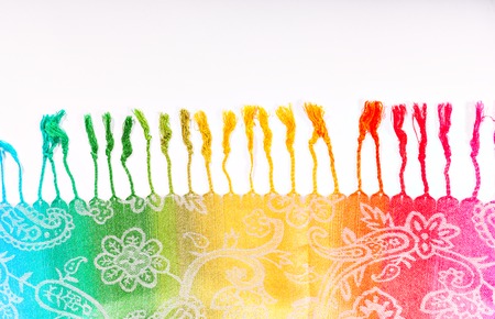 Colors of the rainbow bands on Indian fabric as a background. Rainbow gradient with a traditional pattern on stoles. Brushes on the scarf.The colors of the rainbow LGBT community. Symbol gay.  Isolation on a white background.の写真素材