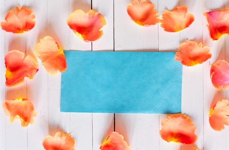 Pink rose petals around the envelope. Romantic pearl blue envelope with space for a signature on a...