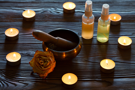 singing bowl on dark wooden background. Burning candles and oil for aromatherapy and massage..の写真素材