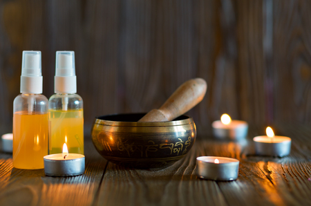 singing bowl on dark wooden background. Burning candles and oil for aromatherapy and massage..の写真素材