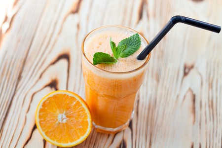 Fresh fruit orange and carrot smoothie on a wooden table. smoothie conceptの写真素材