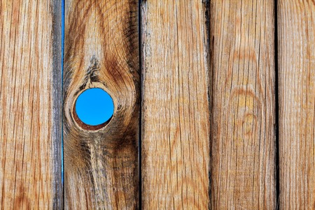 Old wooden wall texture or background with copy space. Old wooden board with a hole in the sky background.の写真素材