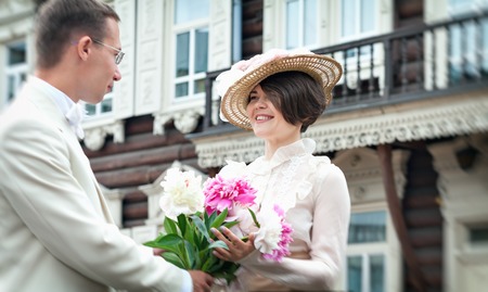 Beautiful young woman in dress and hat portrait in retro style. The young gentleman and lady. Vogue Clothing in vintage styleの写真素材