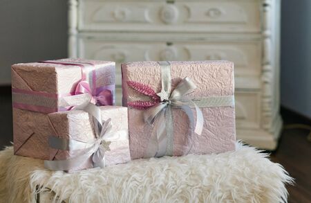 Holiday gift boxes decorated with ribbon. Beautiful purple shiny package for Christmas and New Year. Sebebryannaya tape. Background with copy space for entering text.の写真素材