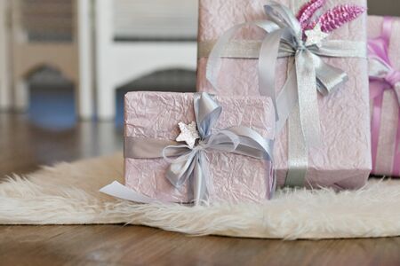 Holiday gift boxes decorated with ribbon. Beautiful purple shiny package for Christmas and New Year. Sebebryannaya tape.の写真素材