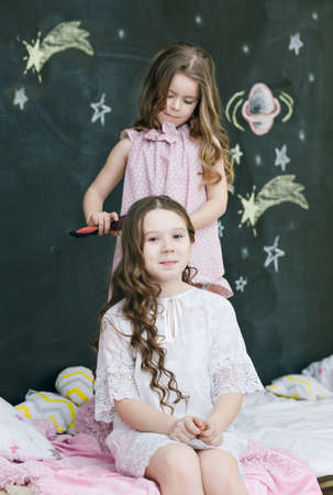 Girl making a hairdo for sisterの写真素材