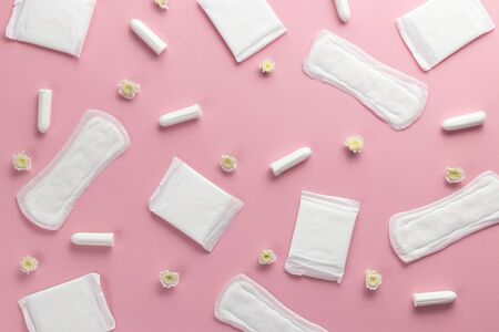 Tampons, feminine sanitary pads on a pink background. Hygienic care on critical days. menstrual cycle. Caring for womens health. Monthly protection. Flat lay, top view, copy space.の写真素材