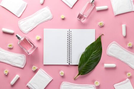 Tampons, feminine sanitary pads and empty paper on a pink background. Hygienic care on critical days. menstrual cycle. Caring for womens health. Monthly protection. Flat lay, top view, copy space.の写真素材